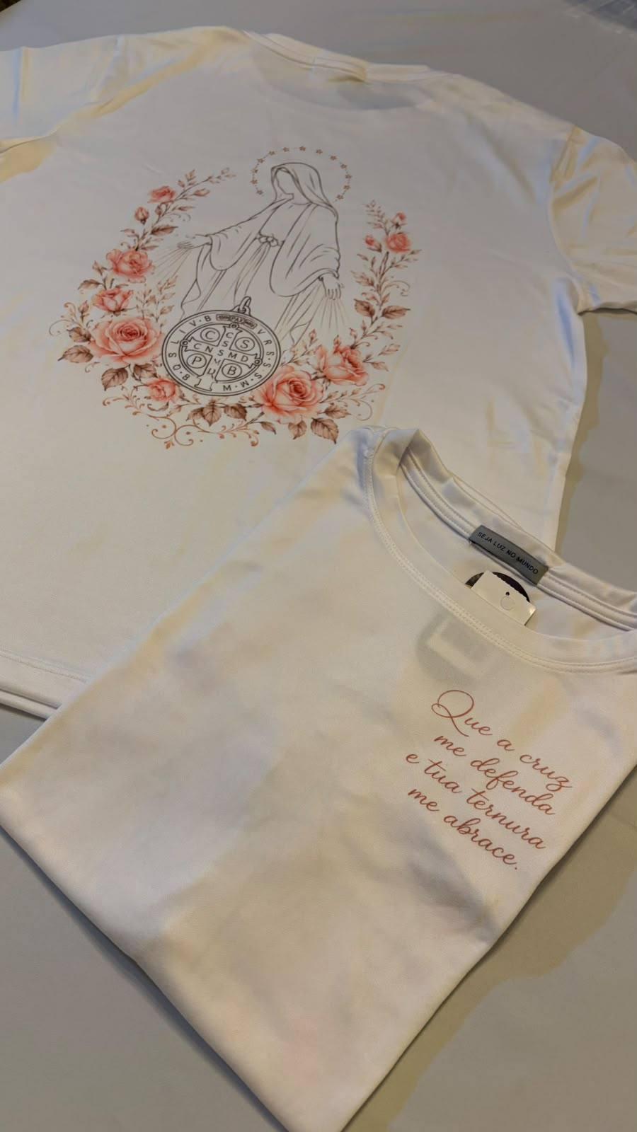 T-SHIRT - QUE A CRUZ ME DEFENDA E TUA TERNURA ME ABRACE